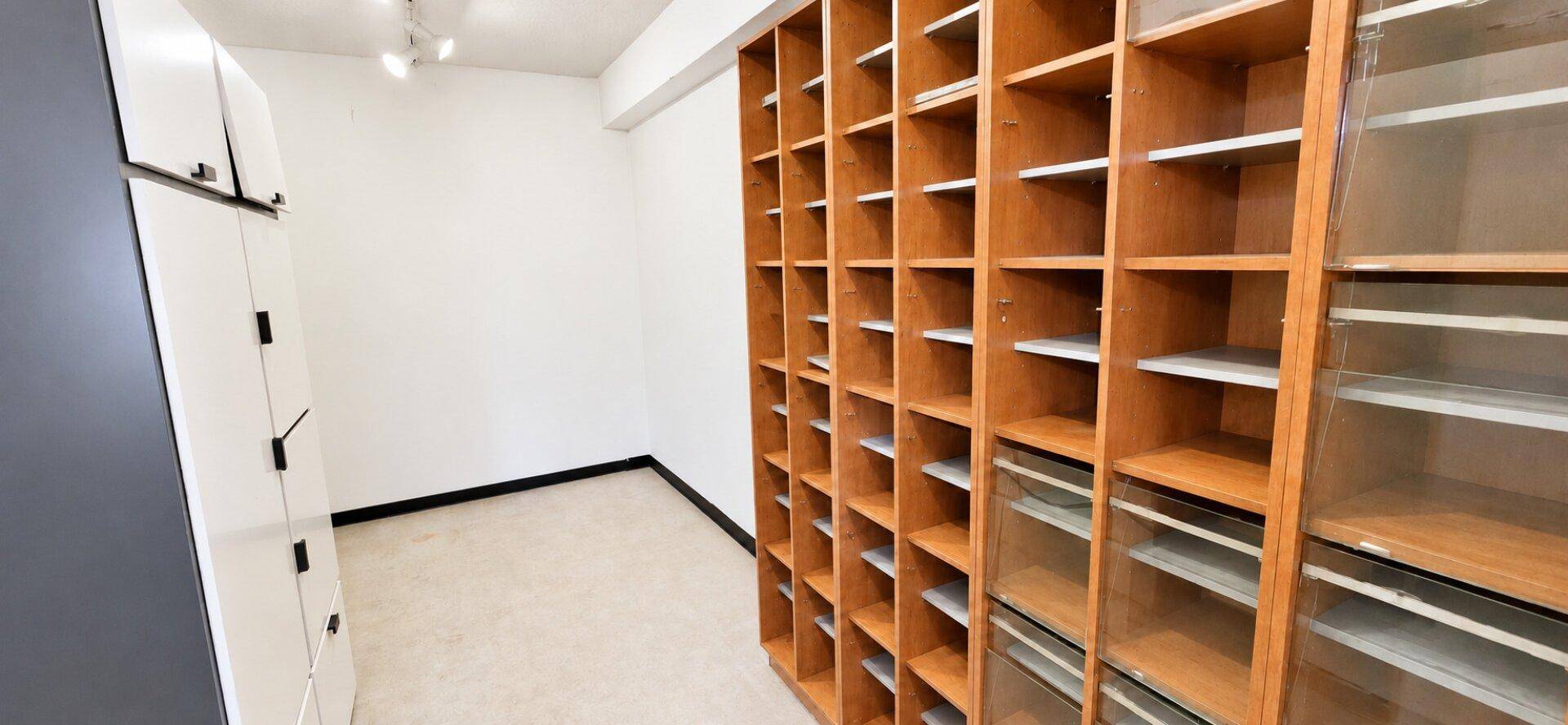 Raum mit hohen, holzfarbenen Regalsystemen, ideal für Lagerung oder Archivierung von Dokumenten.