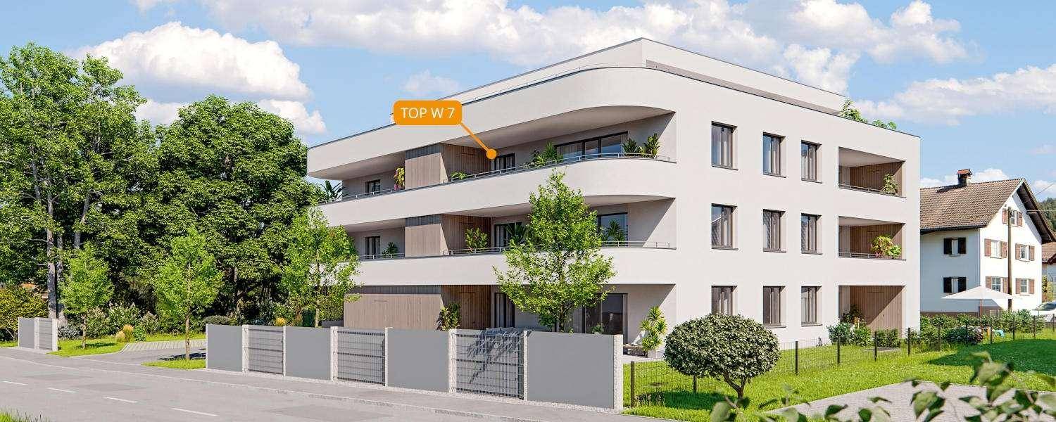 Moderne Wohnanlage mit klarer Architektur und Balkonen, eingebettet in eine grüne Umgebung.