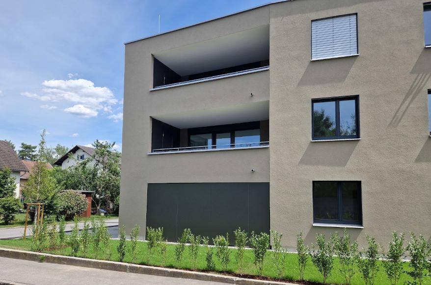 Nahaufnahme der modernen Gebäudefassade mit integrierten Balkonen und großen Fenstern.