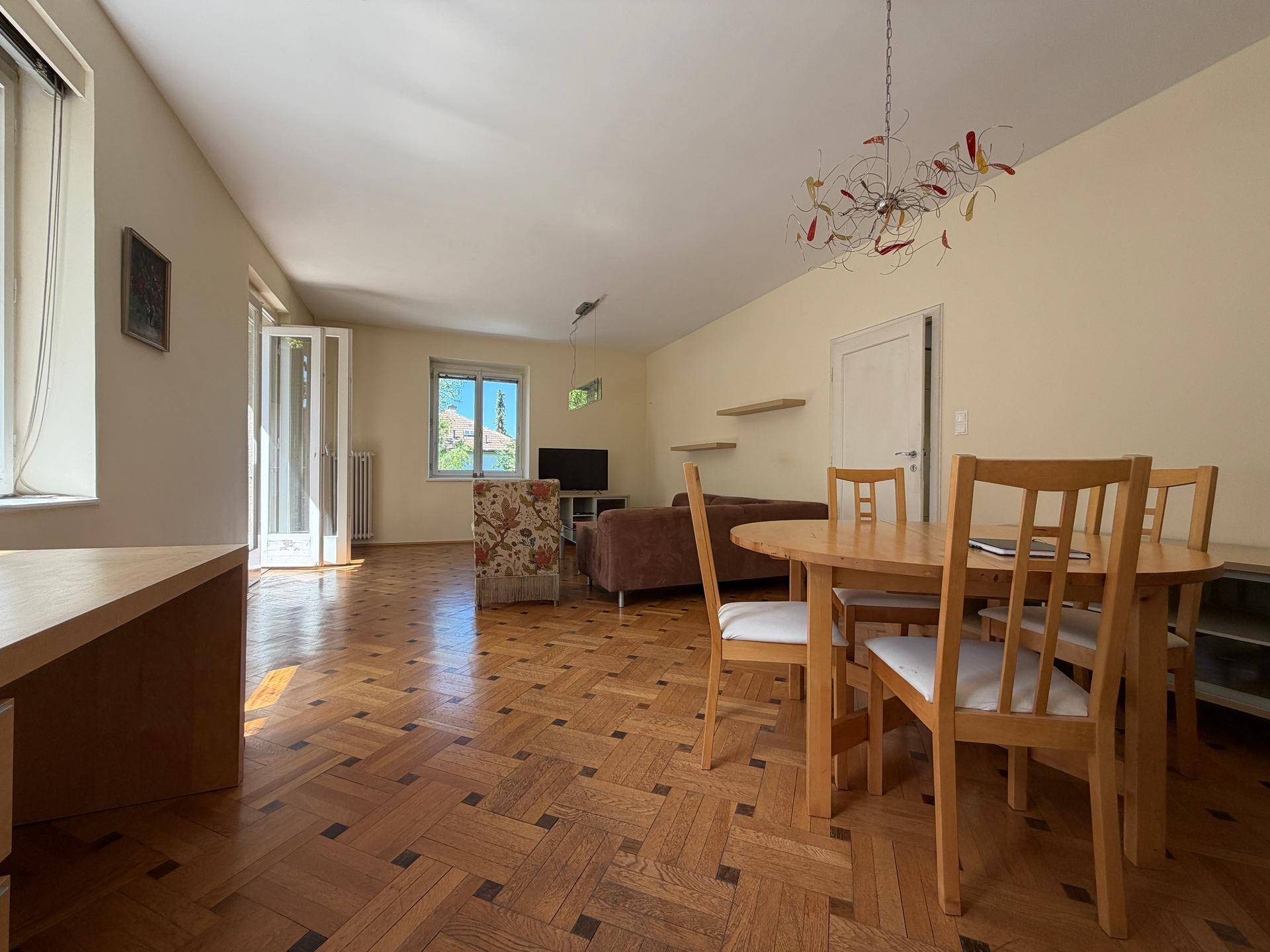 Helles Wohn- und Esszimmer mit Fischgrätparkett, Esstisch und gemütlicher Sofaecke.