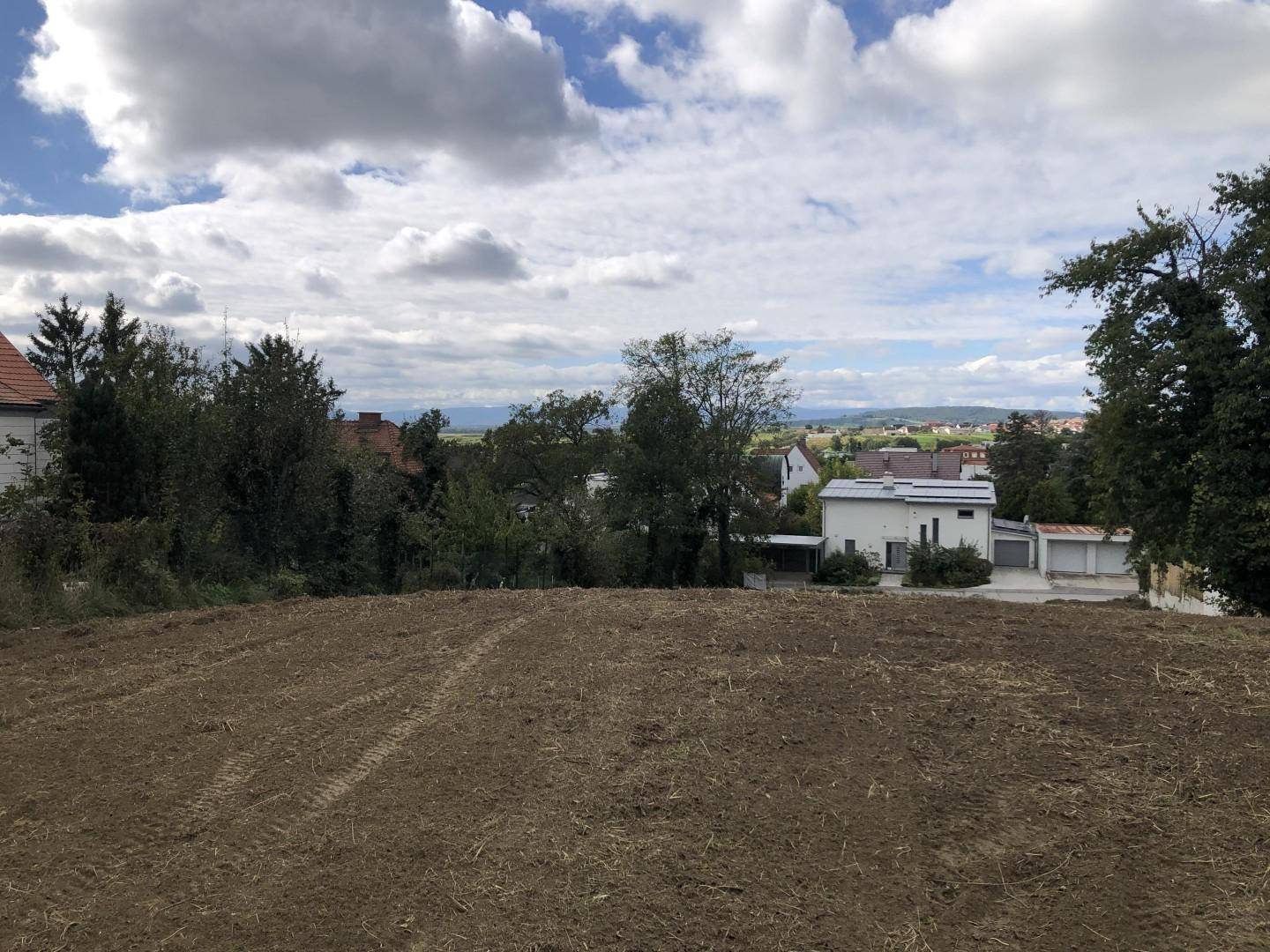 Offenes Grundstück mit weitem Blick über die umliegende Landschaft und entfernte Berge.