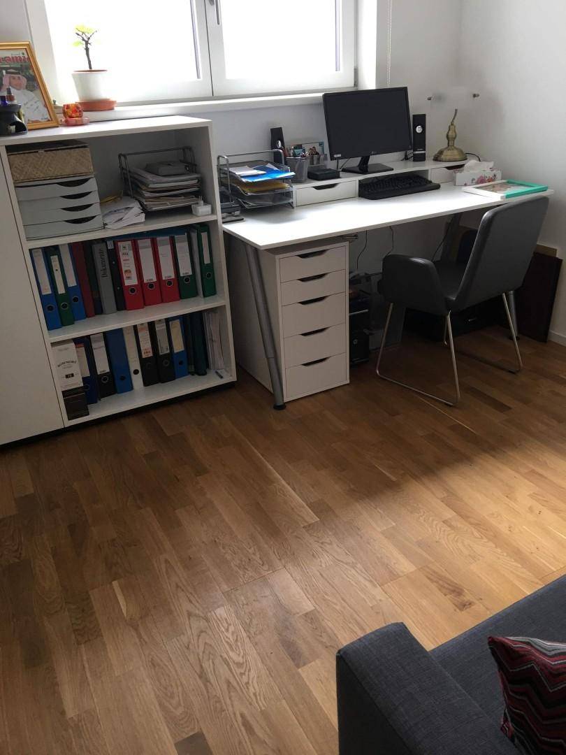 Funktionales Heimbüro mit Schreibtisch, Bürostuhl und Regal, ausgestattet für produktives Arbeiten.