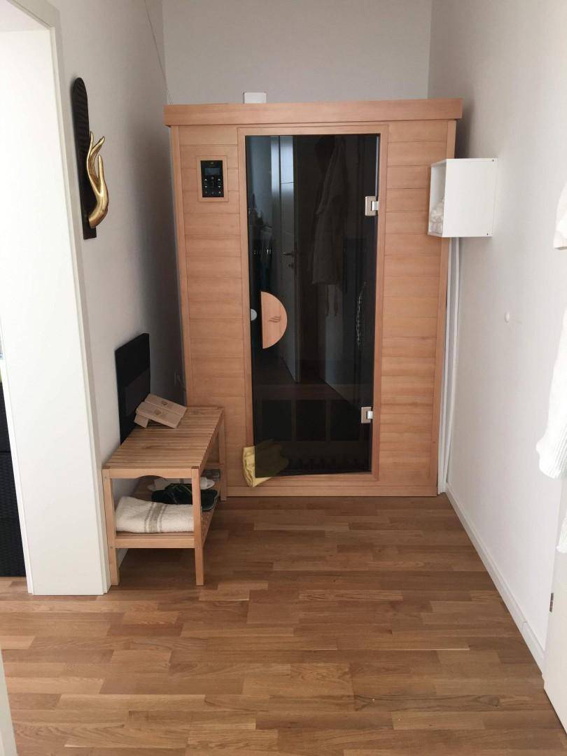 Kleiner Raum mit einer modernen Infrarotsauna und Holzboden, ideal zur Entspannung.