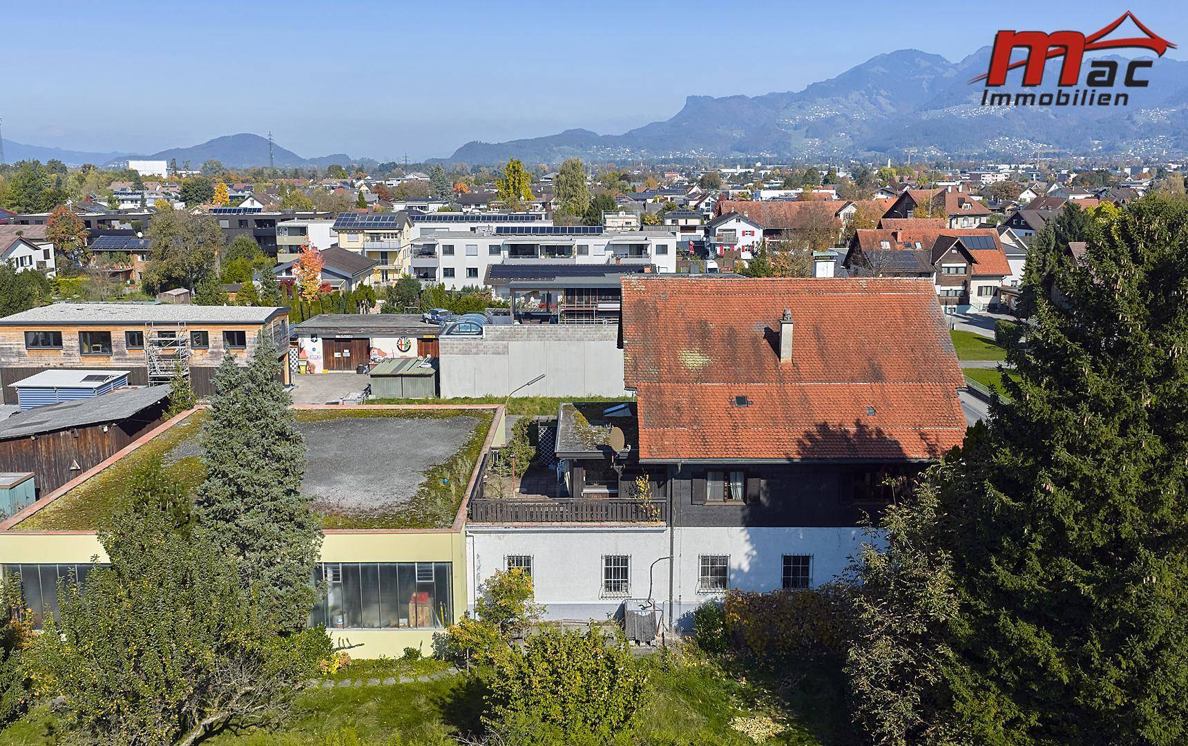 Luftaufnahme des Anwesens und der umliegenden Wohngegend mit weitem Bergblick.