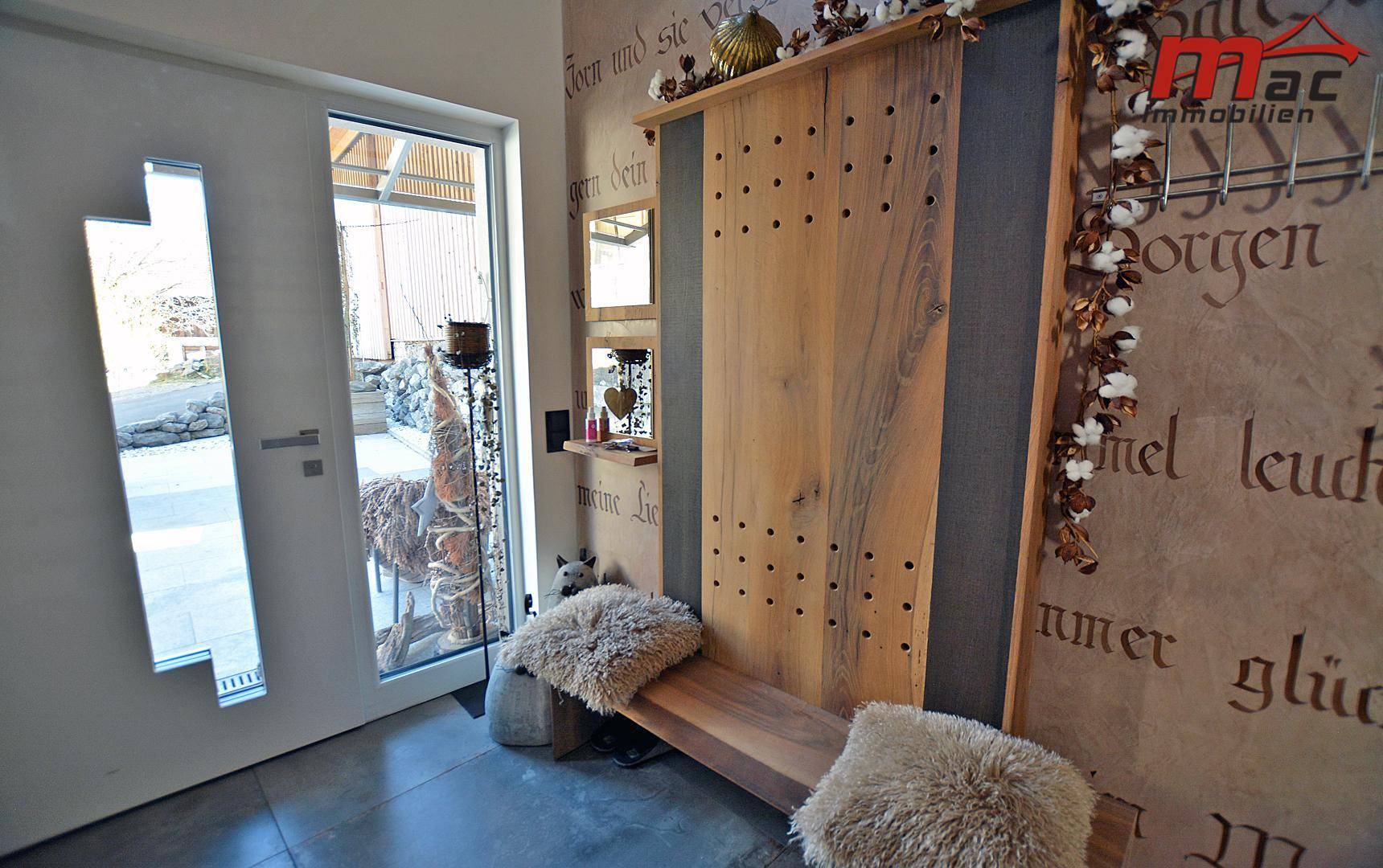 Heller Eingangsbereich mit Holzbänken und dekorativer Wandgestaltung.