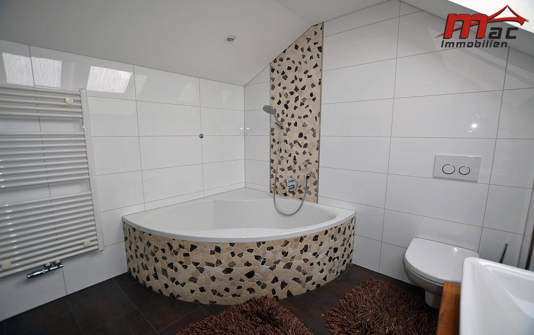 Modernes Badezimmer im Dachgeschoss mit Eckbadewanne, Dusche und Dachfenstern.