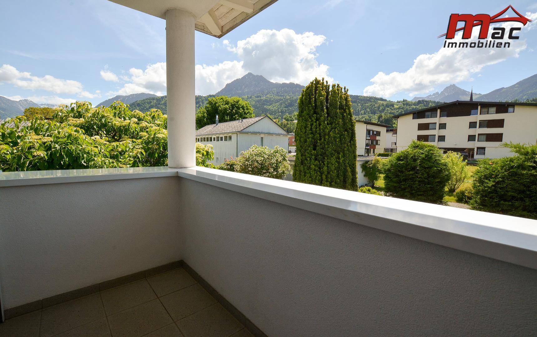 Geräumiger Balkon mit Fliesenboden und atemberaubendem Blick auf die umliegenden Berge.