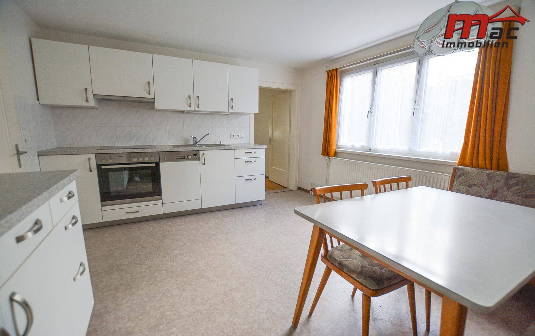 Geräumige Küche mit Einbauküche, Essbereich und großem Fenster für viel Tageslicht.