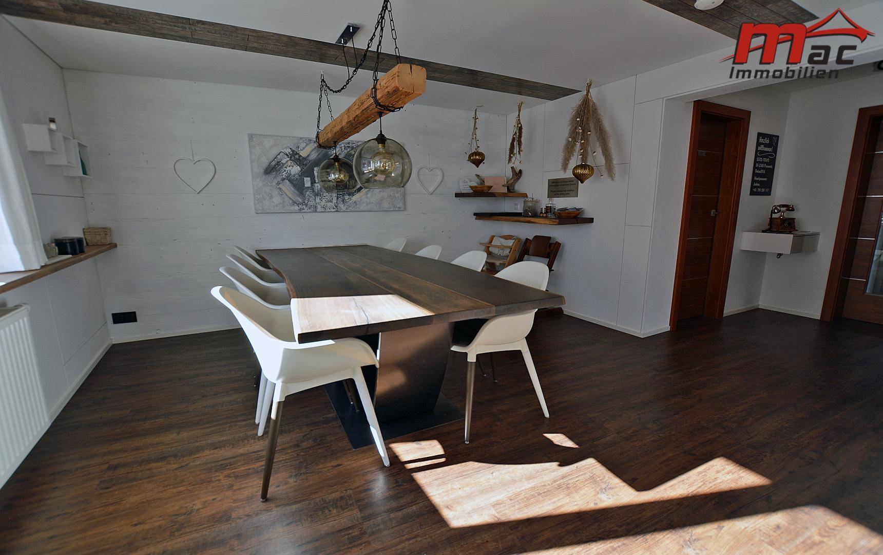 Geräumiger Essbereich mit Holztisch und Deckenbalken, hell und einladend.