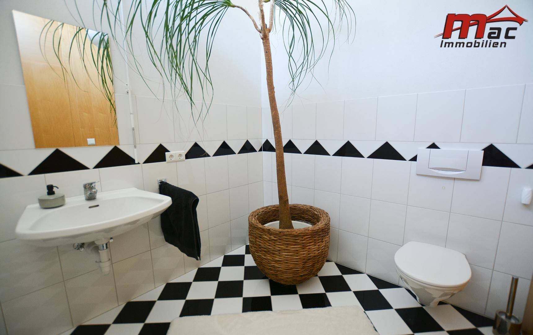 Modernes Gäste-WC mit schwarz-weißem Schachbrettmuster-Fliesenboden und Wand-WC.