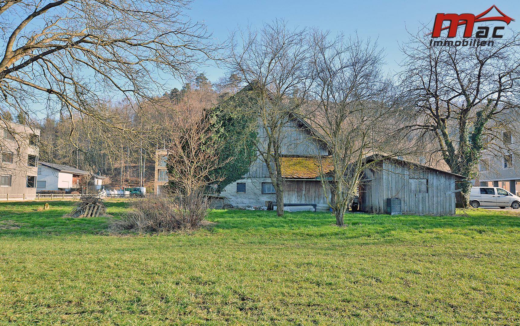 Rückansicht des Hauses mit angrenzendem Scheunenteil und weitläufiger Grünfläche.
