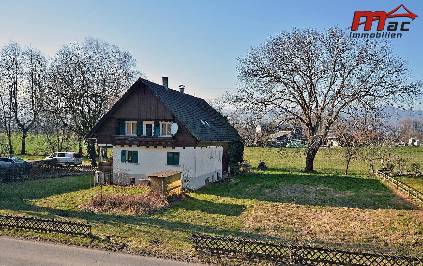 Seitenansicht des Hauses mit großem Garten und weitem Blick in die Landschaft.