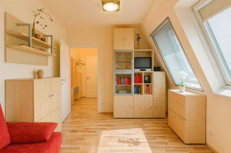 Heller Wohnbereich mit Dachschräge, Holzmöbeln und einem großen Dachfenster für viel Licht.