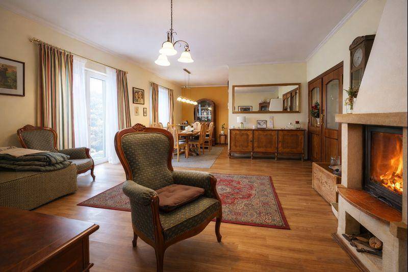Gemütlicher Wohn-Essbereich mit Kamin, Holzboden und traditionellen Möbeln.