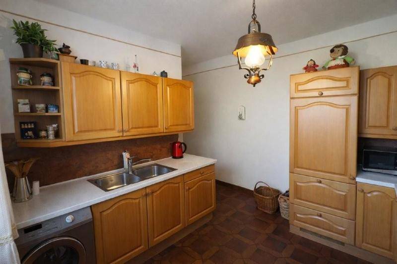 Traditionelle Holzküche mit Einbauschränken, Spüle und Arbeitsplatte, funktional und gemütlich eingerichtet.