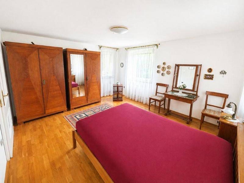Geräumiges Schlafzimmer mit Holzboden, großen Holzschränken und einem Schminktisch.