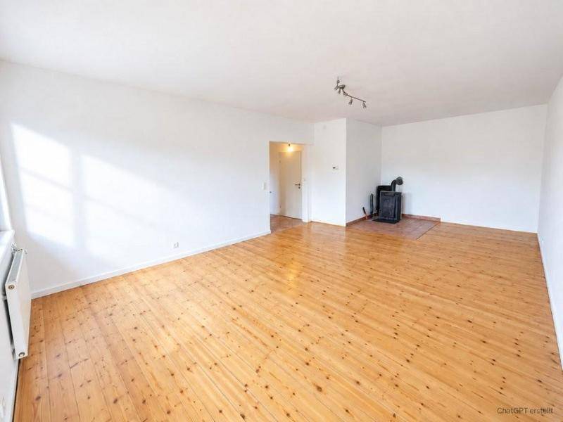 Helles Wohnzimmer mit Holzdielenboden und einem Holzofen in der Ecke.