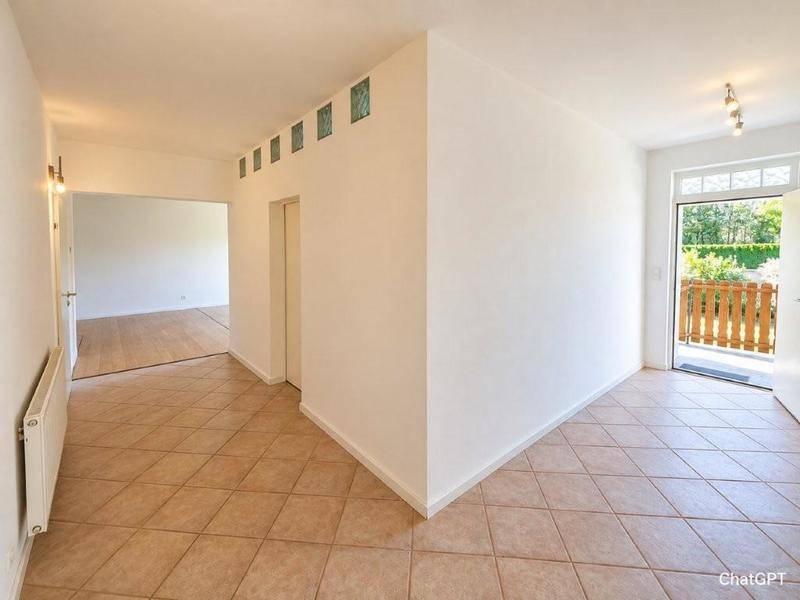 Heller Eingangsbereich mit Terrakotta-Fliesenboden und Zugang zu einem Außenbereich.