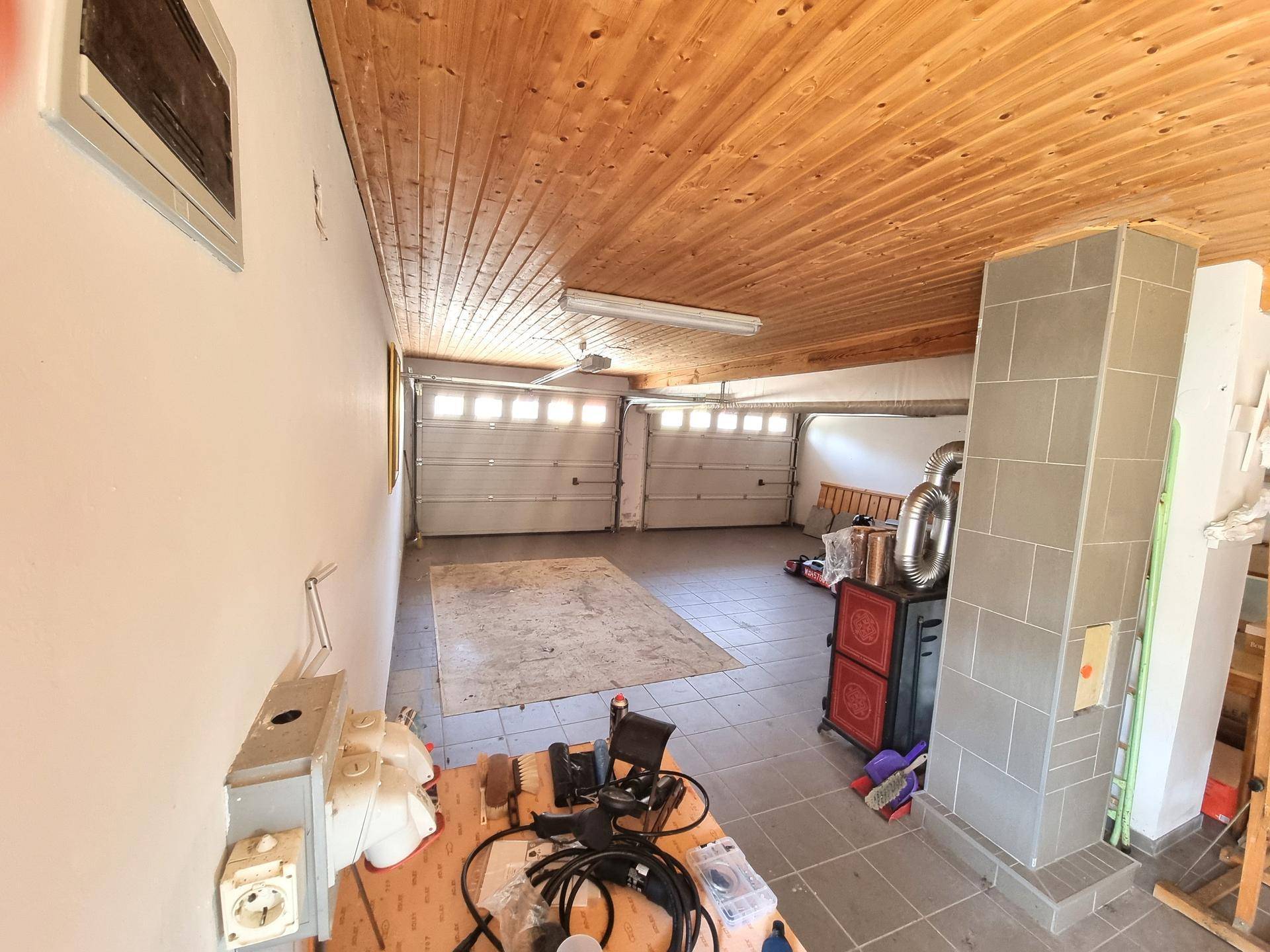 Geräumige Doppelgarage mit Holzdach und Platz für Fahrzeuge sowie Abstellmöglichkeiten.