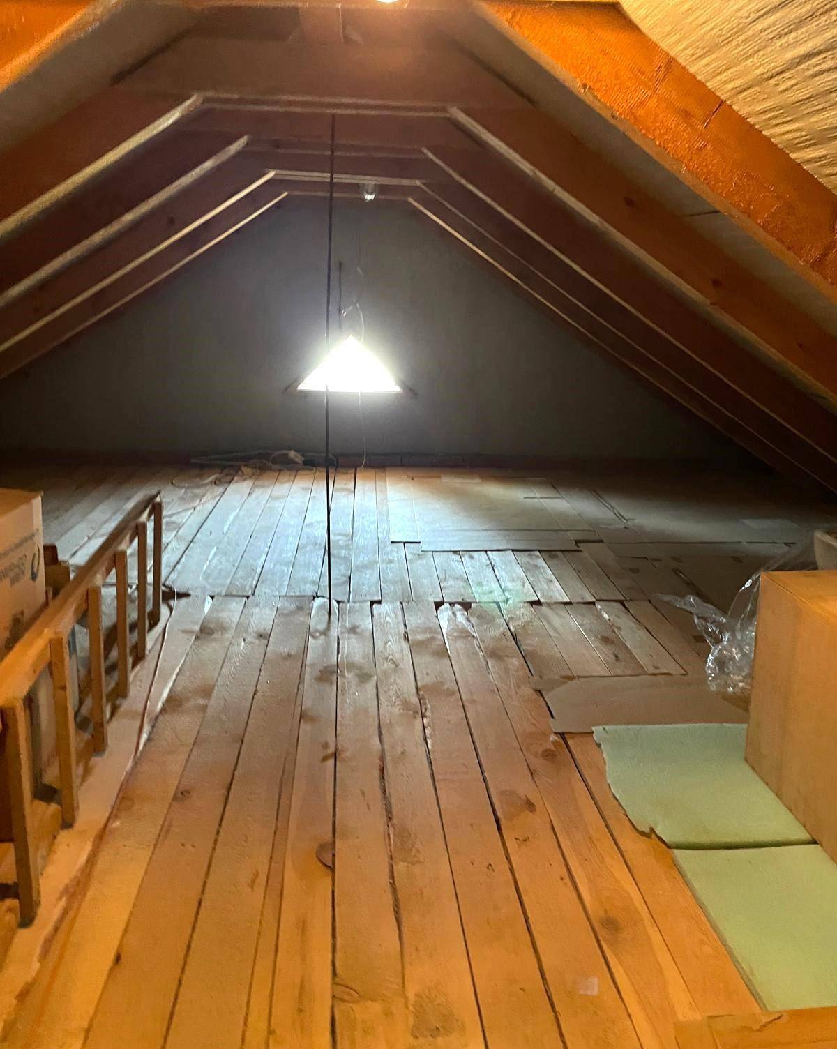 Geräumiger Dachboden mit Holzboden und sichtbaren Dachbalken, ideal als Abstellfläche.