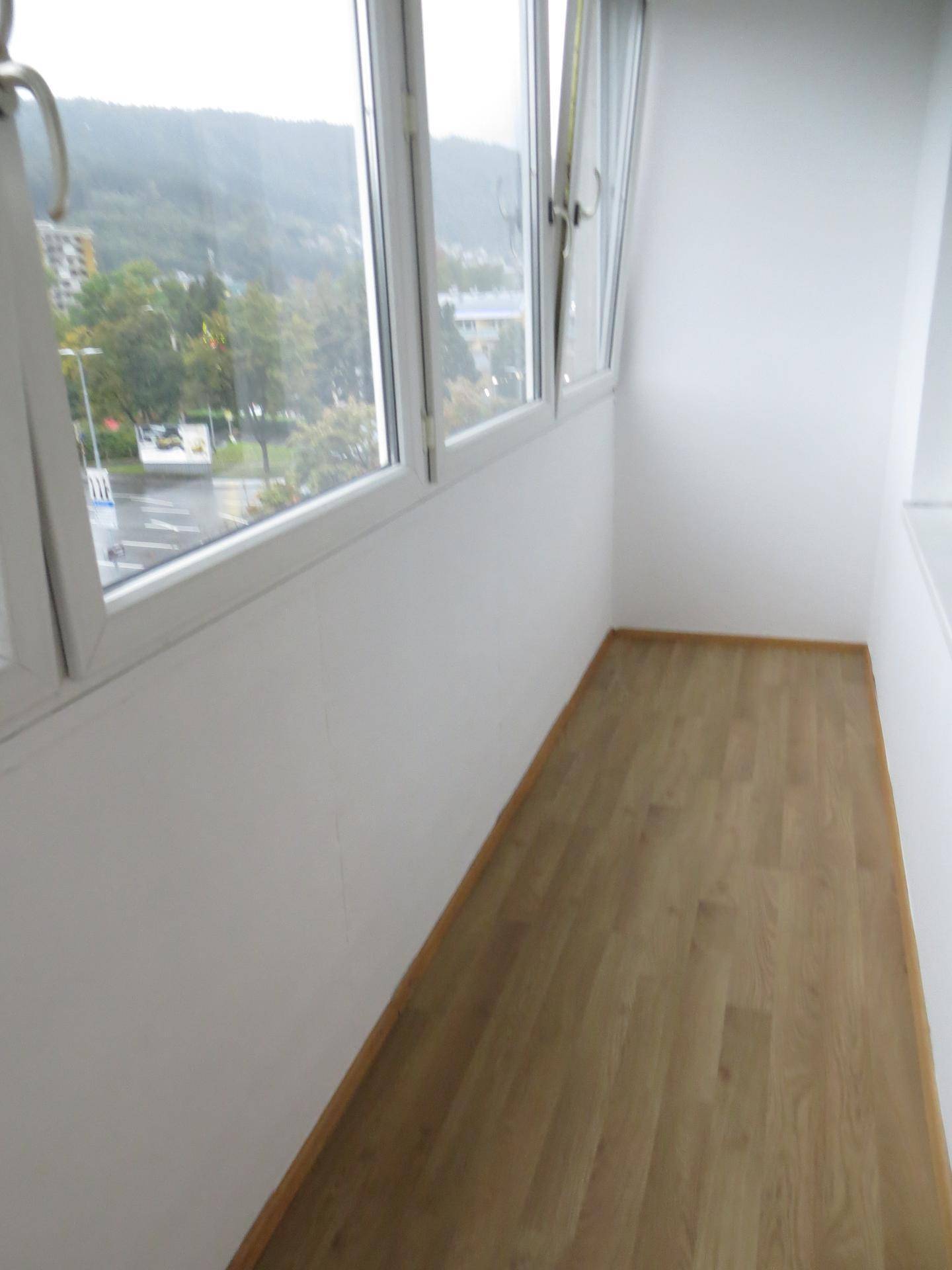 Verglaster Balkon oder Wintergarten mit Panoramablick auf die Umgebung und die Berge.