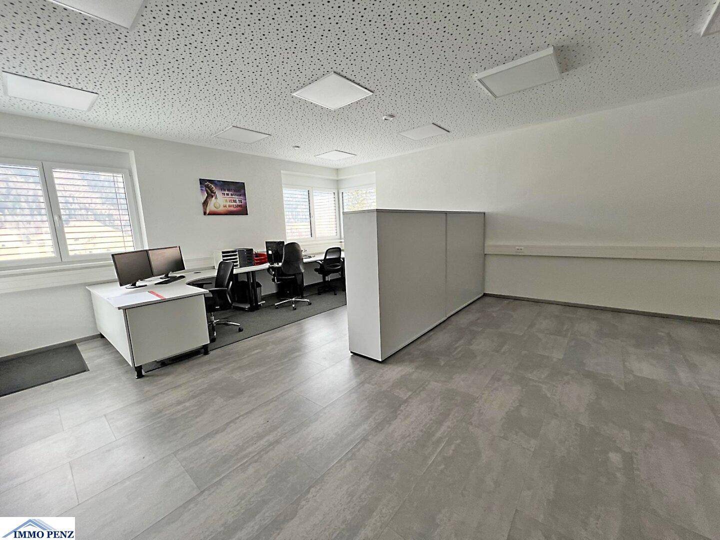 Helles Büro mit mehreren Arbeitsplätzen, modernen Schreibtischen und großen Fenstern, bereit zur individuellen Gestaltung.
