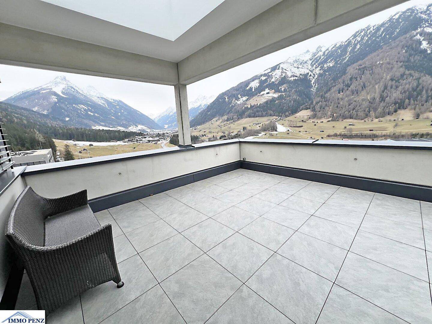 Große Terrasse mit Fliesenboden und atemberaubendem Panoramablick auf die schneebedeckten Berge.