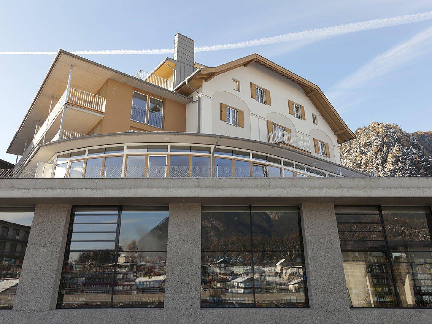 Zeitgenössische Architektur mit großen Glasflächen und Balkonen unter einem klaren Himmel.