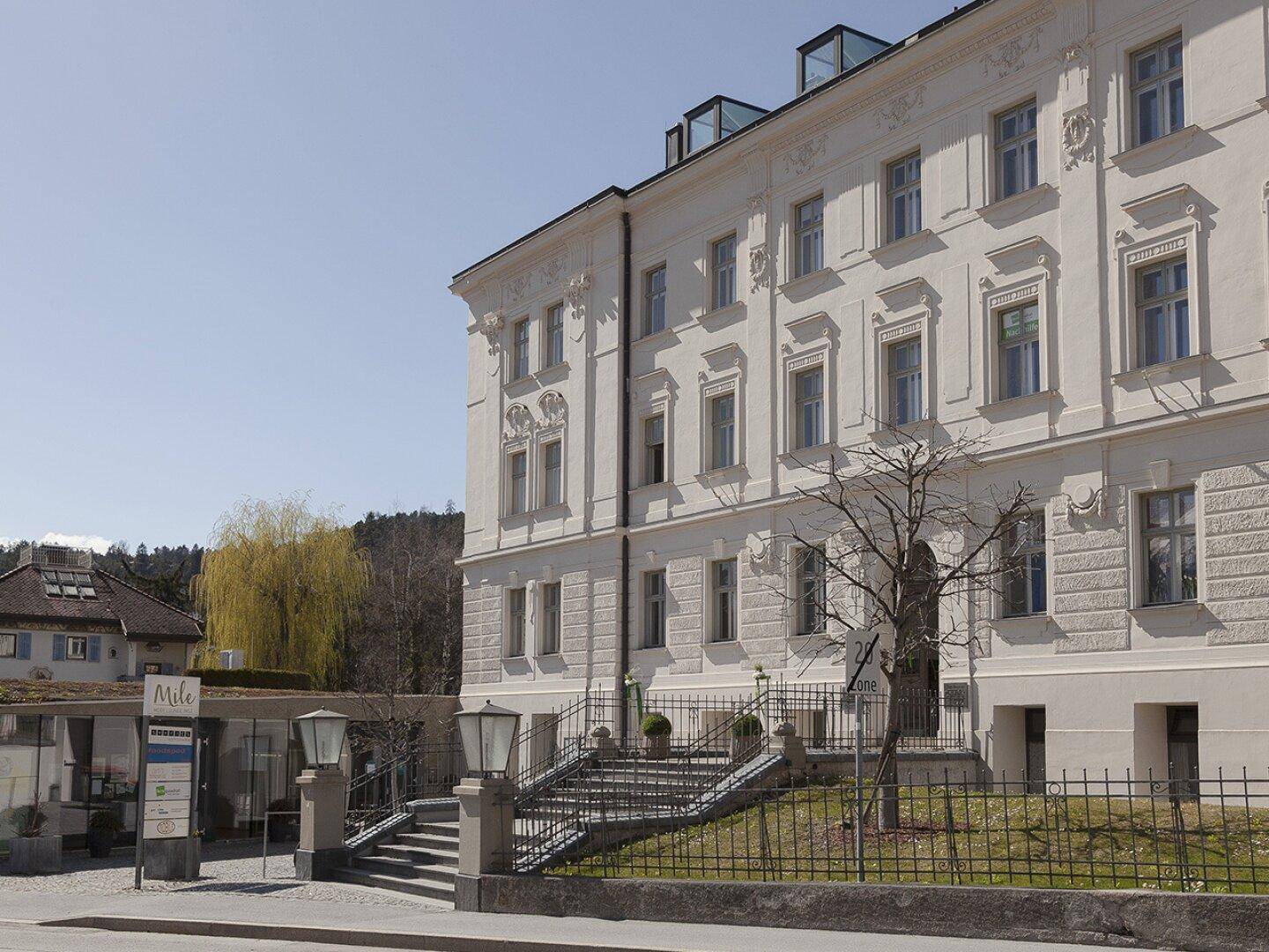 Elegante historische Fassade eines Gebäudes mit vielen Fenstern und klassischer Architektur.