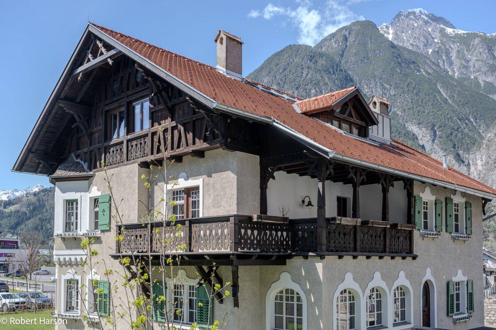 Detailansicht eines traditionellen Gebäudes mit Holzbalkonen und Bergblick.