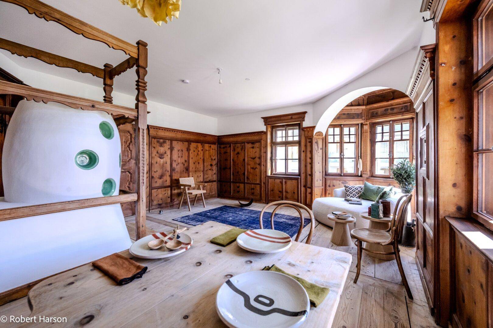 Heller Wohn- und Essbereich mit Holzboden, traditioneller Vertäfelung und gemütlichem Erker, stilvoll eingerichtet.