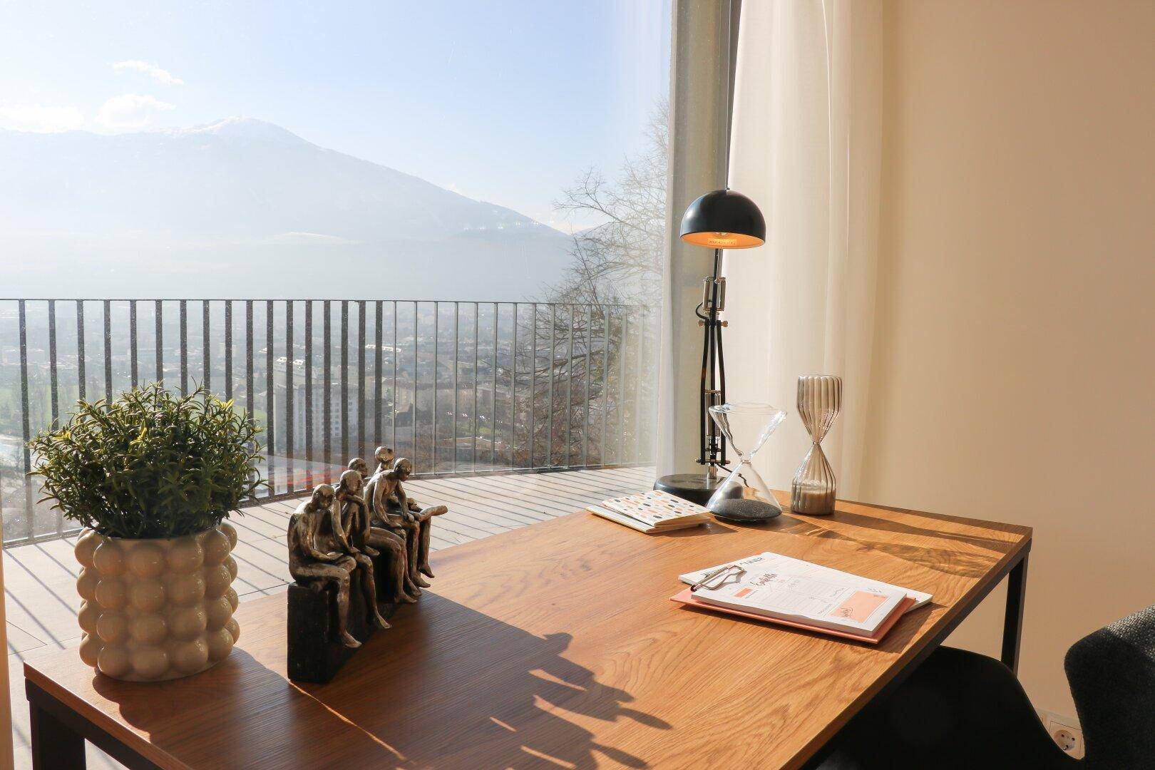 Detailansicht des Schreibtisches mit Dekoration und beeindruckendem Bergblick.