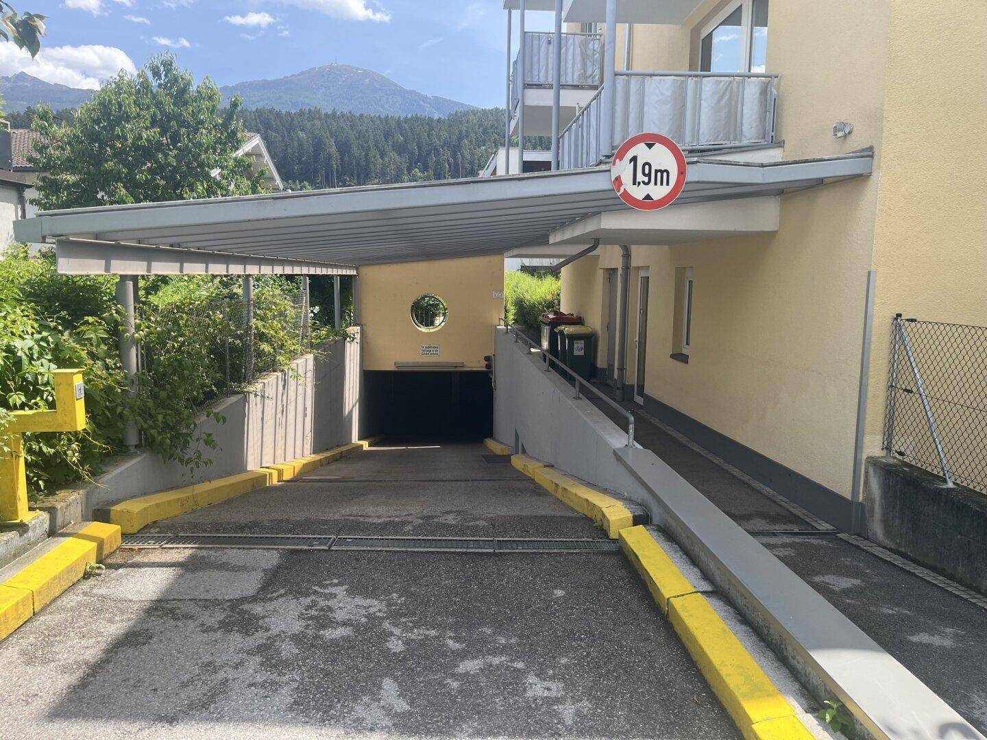 Einfahrt zu einer Tiefgarage mit einer Höhenbegrenzung von 1,9m und einer Rampe.