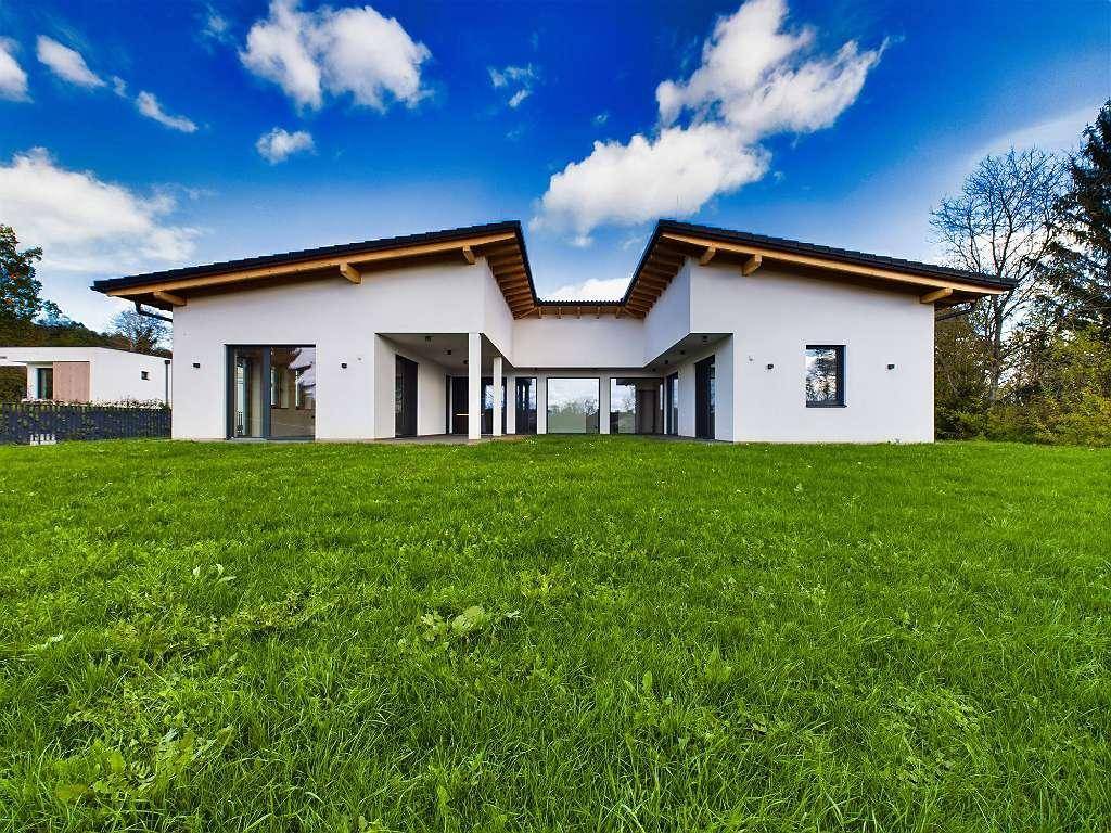Frontansicht der modernen Villa mit minimalistischer Architektur und weitläufigem Gartenbereich.