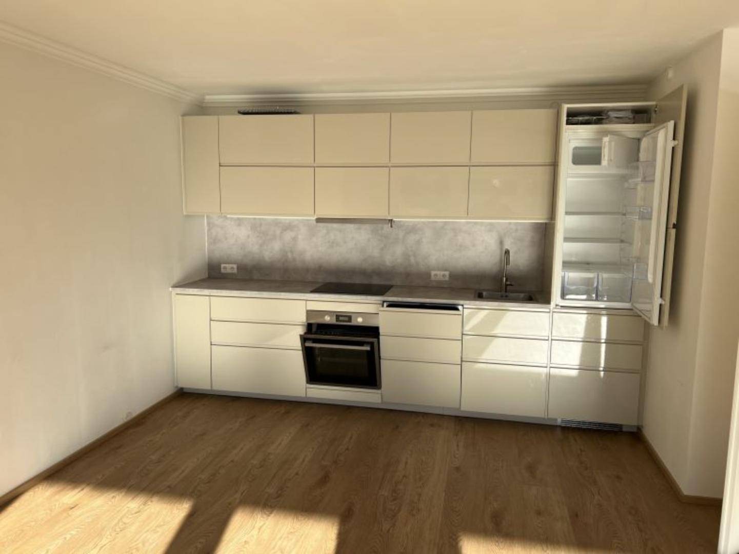 Moderne Einbauküche in hellem Beige mit integrierten Geräten und viel Stauraum.