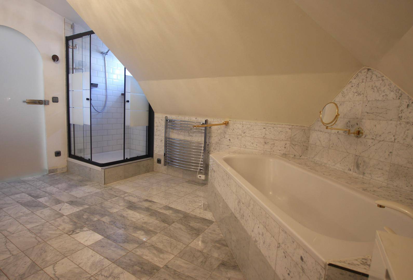 Geräumiges Badezimmer mit Marmorfliesen, Duschkabine, Badewanne und beheiztem Handtuchhalter.