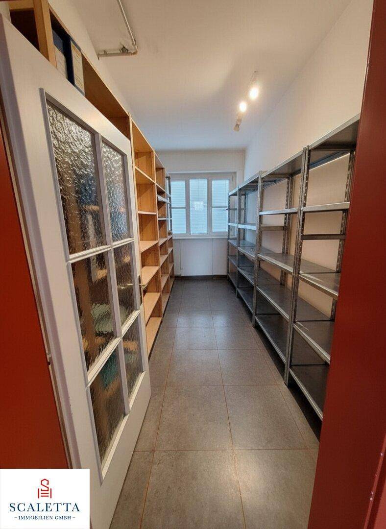 Lagerraum mit Regalen aus Holz und Metall, ideal für Archivierung oder Vorräte, mit Fenster.