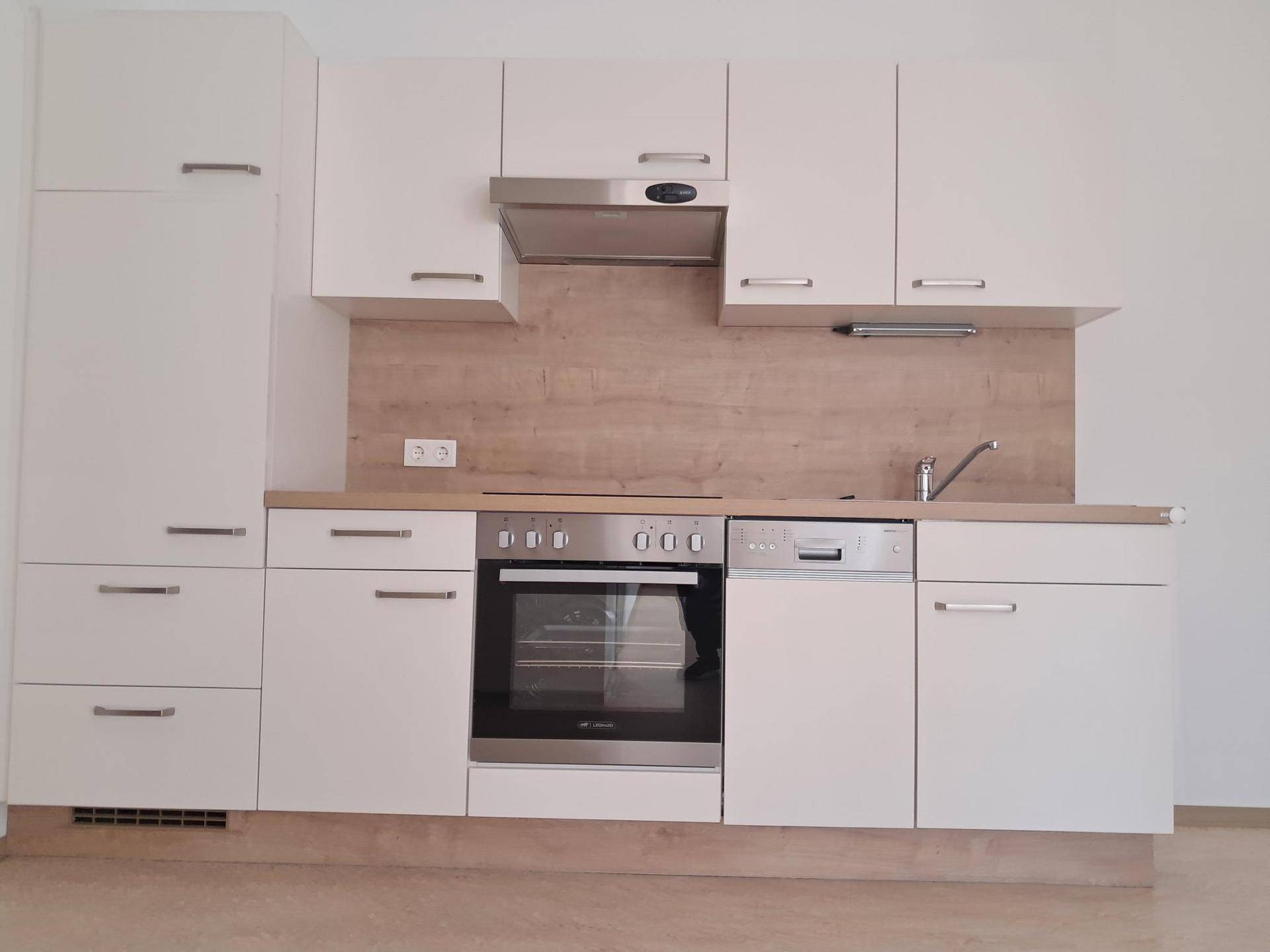 Moderne Einbauküche in Weiß mit Holzoptik-Arbeitsplatte und integrierten Geräten.