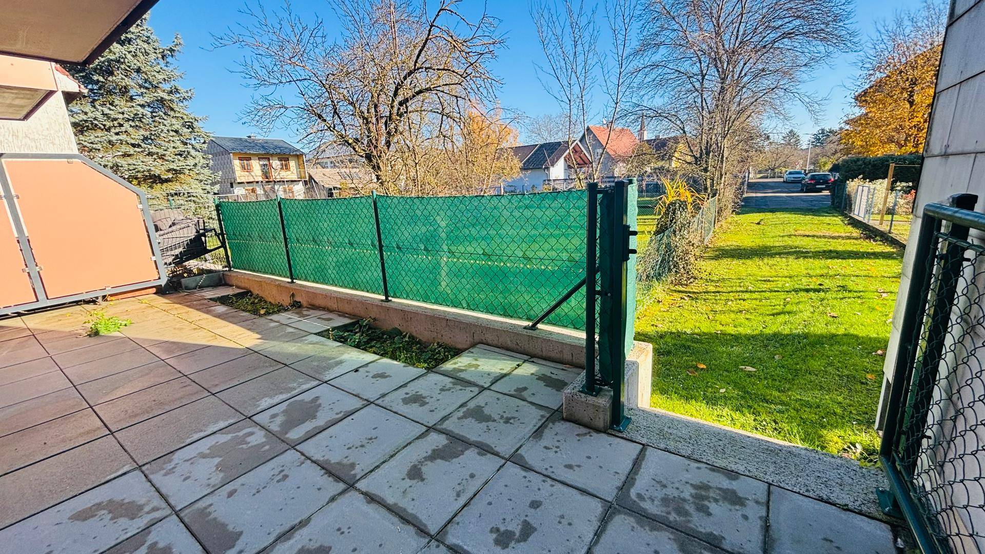 Geräumige Terrasse mit Steinplatten und Treppe zum angrenzenden Gartenbereich.