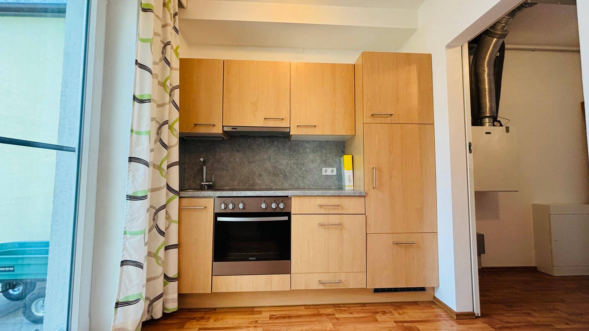 Funktionale Einbauküche mit hellen Holzfronten und modernen Geräten.