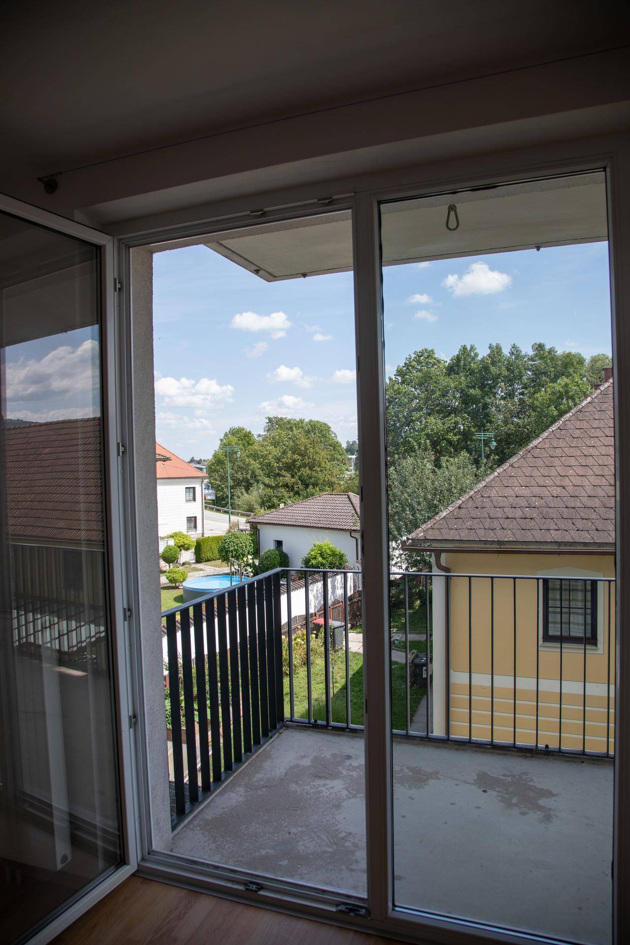 Balkon mit Blick auf die Nachbarschaft und einen Swimmingpool in der Ferne.