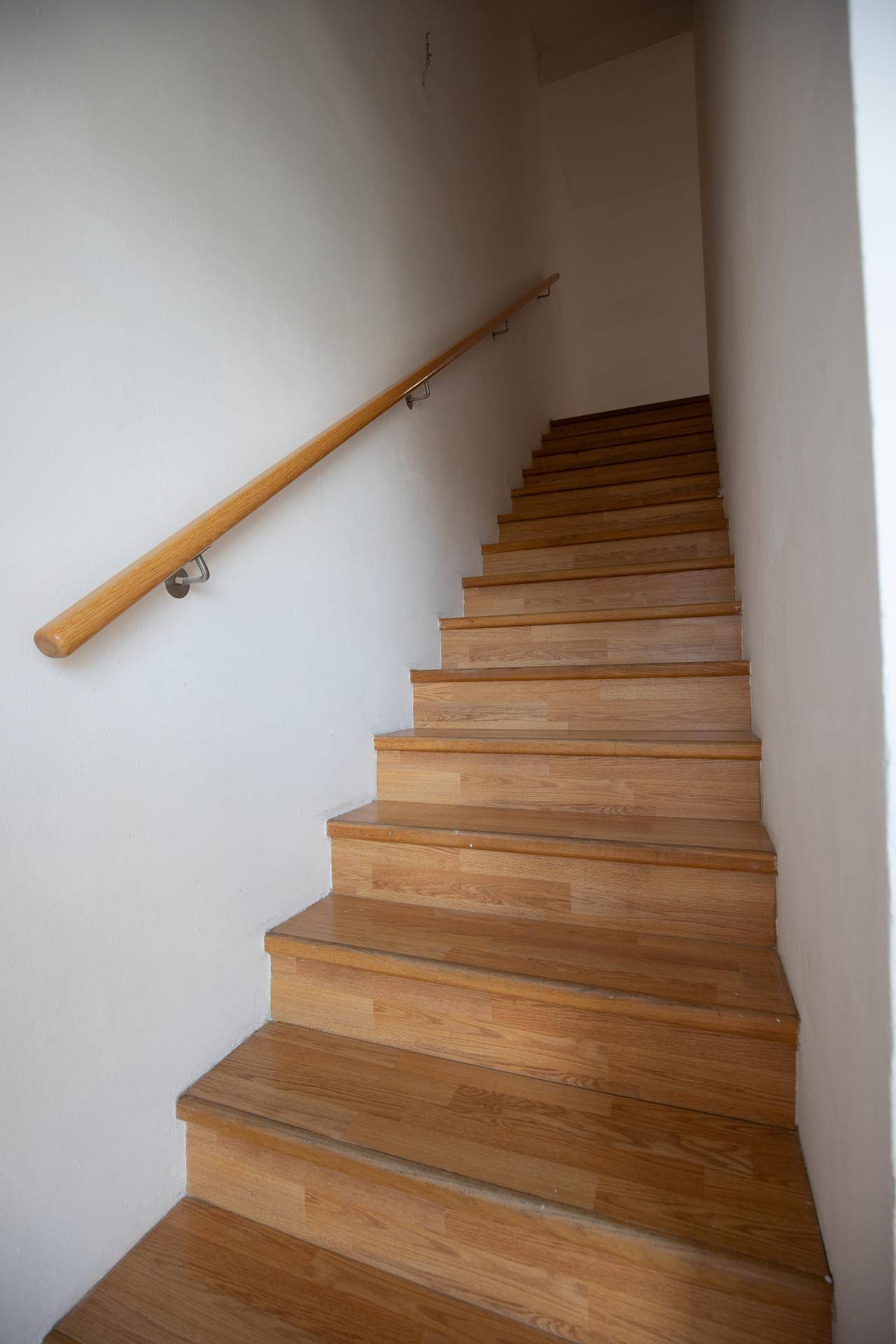 Holztreppe mit Handlauf, die die verschiedenen Ebenen der Wohnung verbindet.