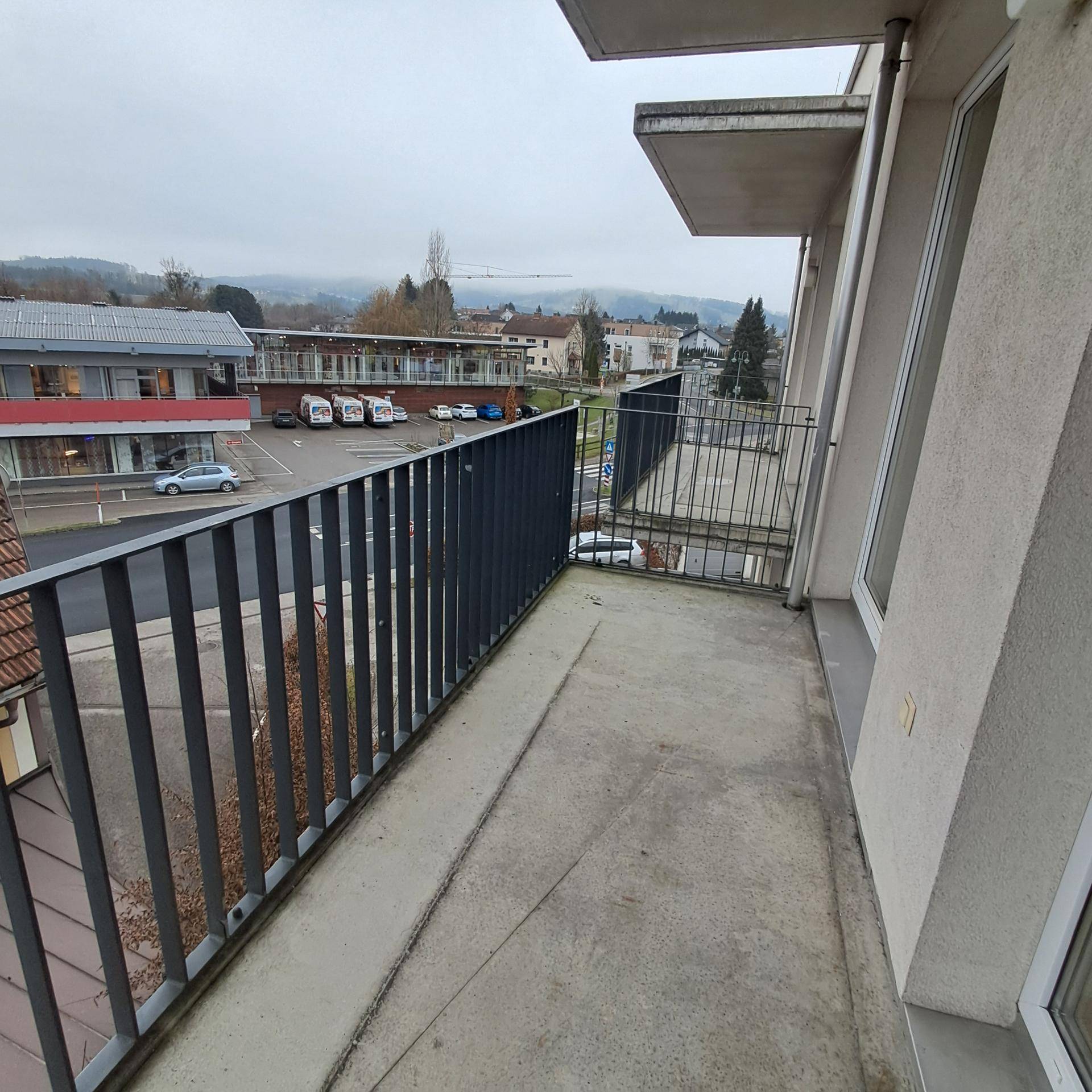 Langer Balkon mit Blick auf die umliegenden Dächer und die Stadt.