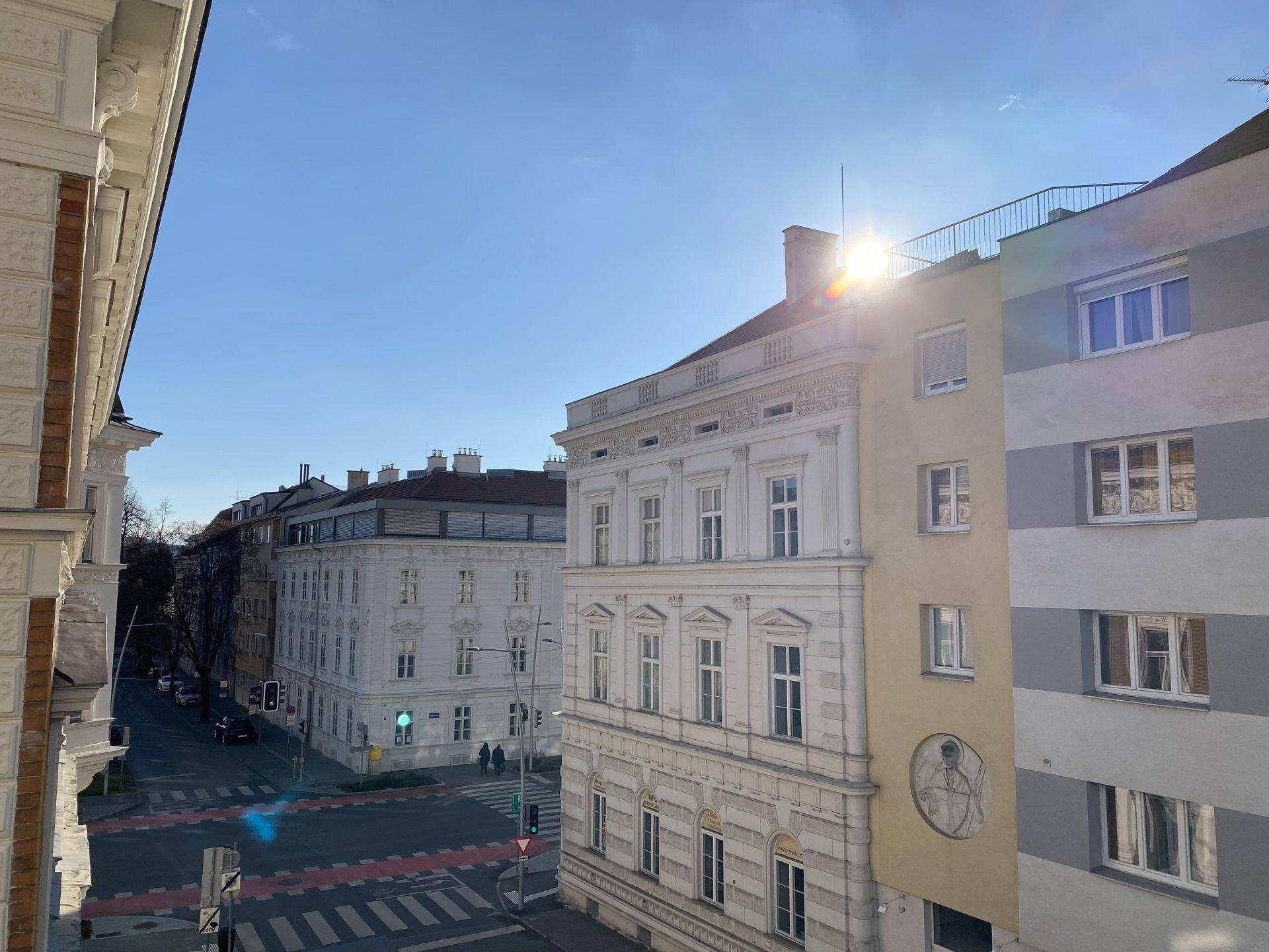 Stadtansicht mit historischen und modernen Gebäuden unter blauem Himmel.