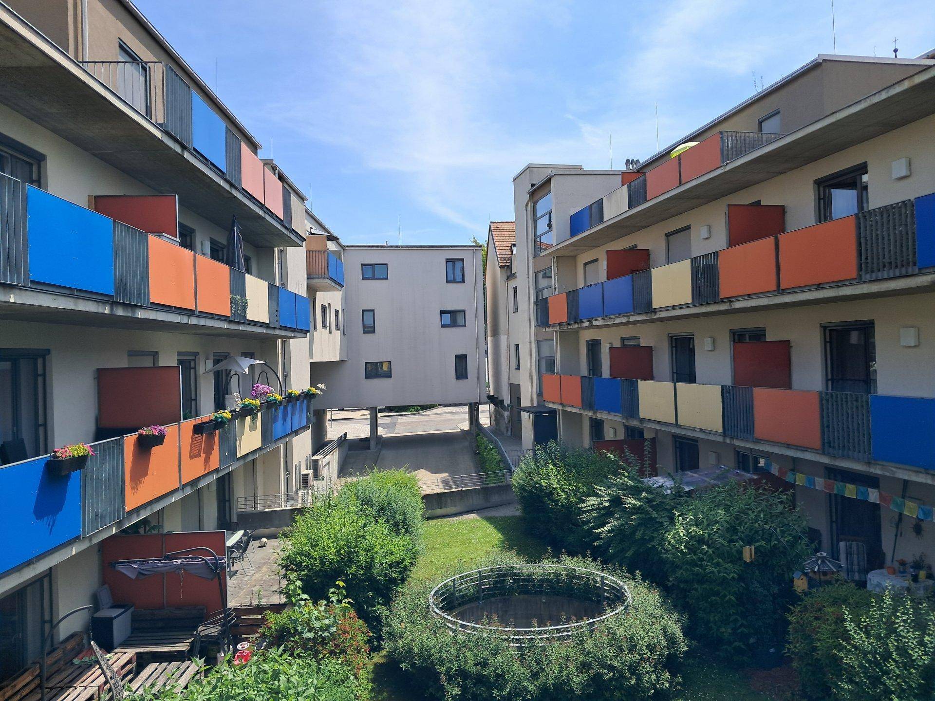 Weitläufiger Blick auf den gemeinschaftlichen Gartenbereich und die umliegenden Wohngebäude.