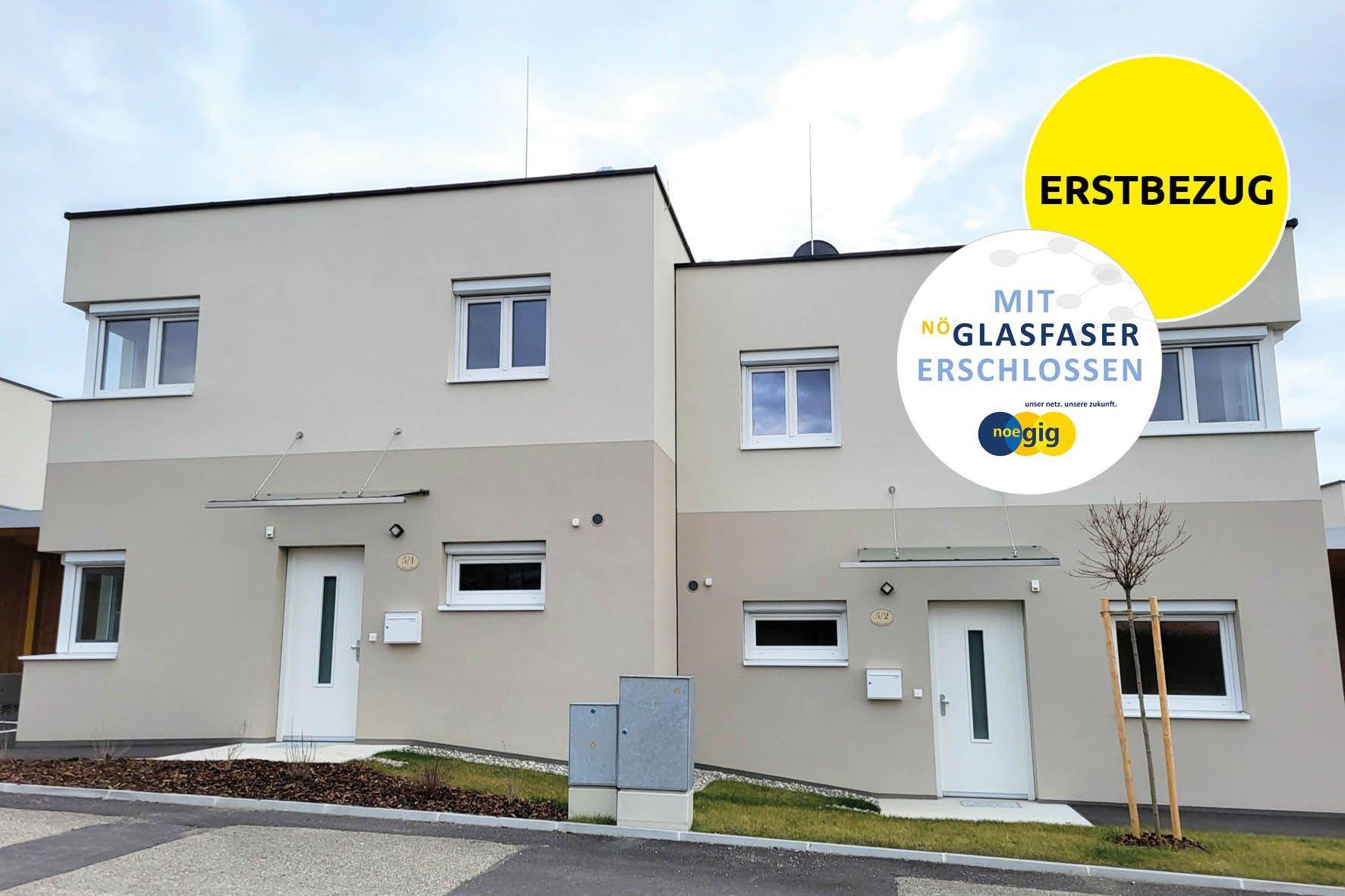 Zwei moderne Reihenhäuser mit heller Fassade, Rollläden und Glasfaseranschluss für Erstbezug.