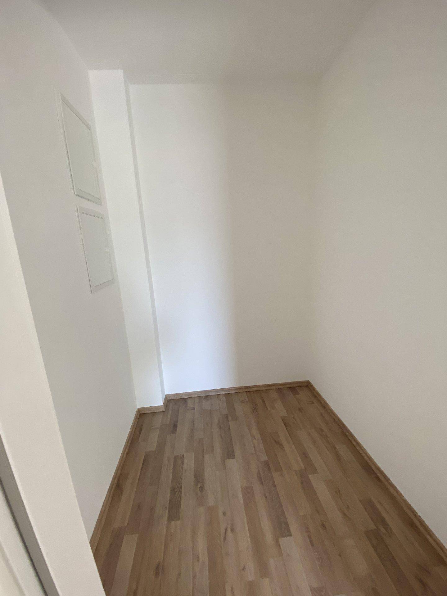 Praktischer Abstellraum mit Laminatboden und weißen Wänden, ideal für zusätzlichen Stauraum.