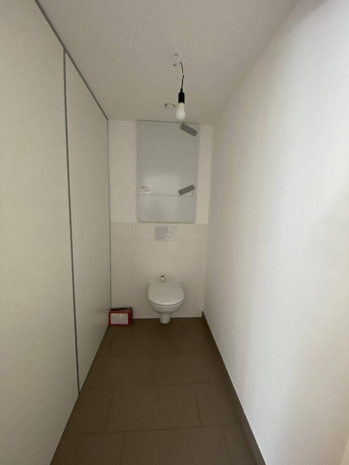 Separates WC mit wandhängender Toilette und Fliesenboden, praktisch und pflegeleicht.