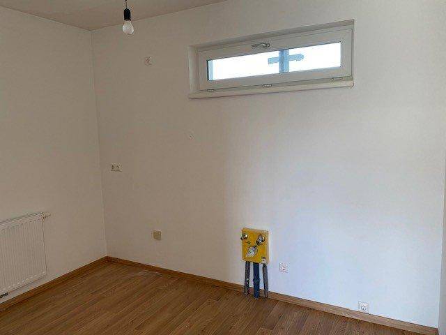Leerer Raum mit Fenster und Anschlüssen für eine mögliche Küchenzeile oder Waschmaschine.