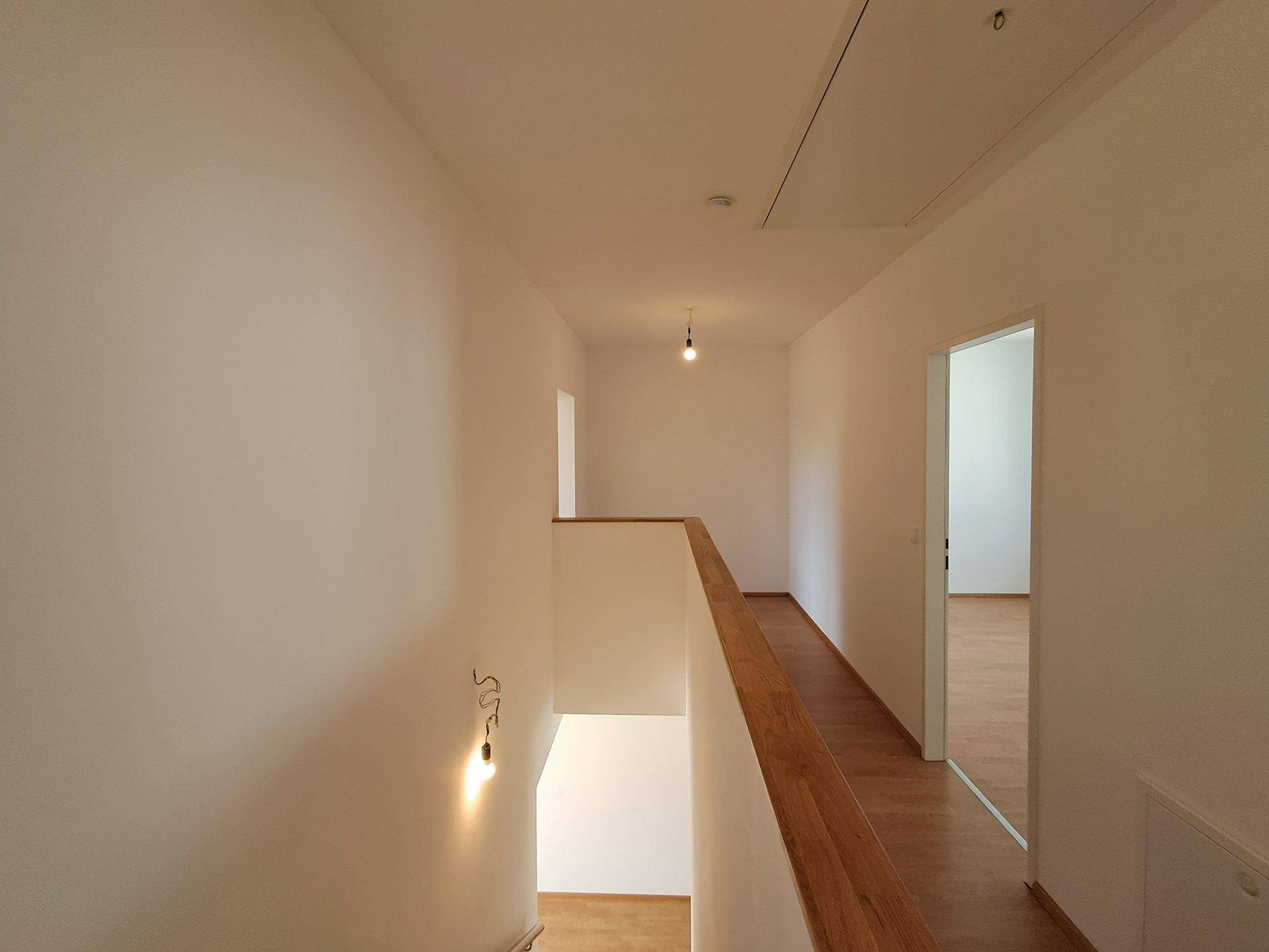 Geräumiger Flur im Obergeschoss mit Laminatboden und Blick auf den Treppenbereich.